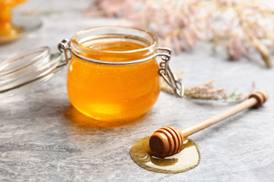 Photo of Fresh honey in jar on grey table