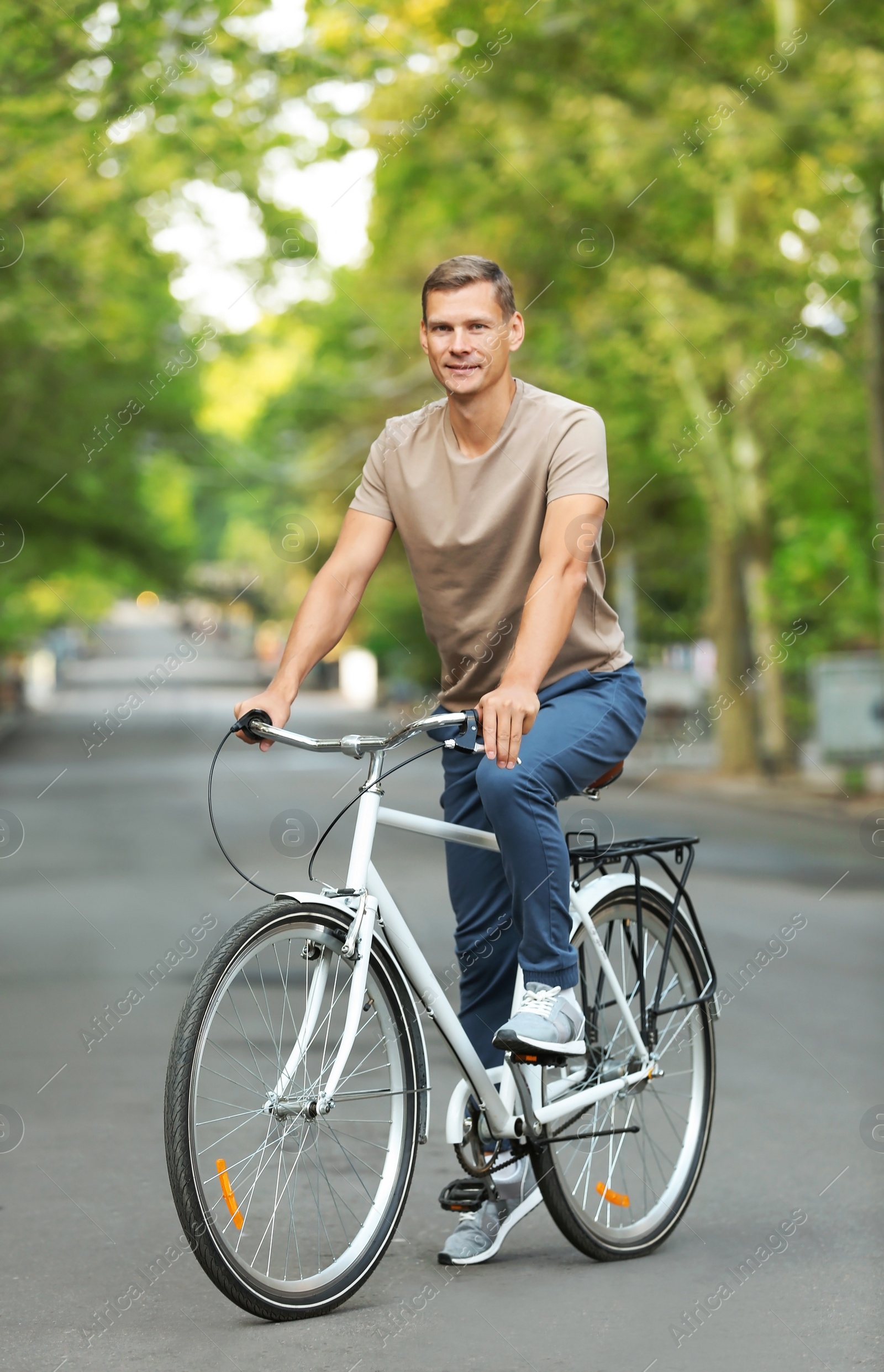 Photo of Handsome man riding bicycle outdoors on summer day