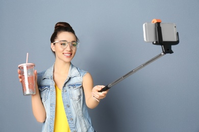 Photo of Young beautiful woman taking selfie against grey background