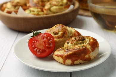 Photo of Fresh delicious puff pastry with tasty filling and tomato on white wooden table, closeup