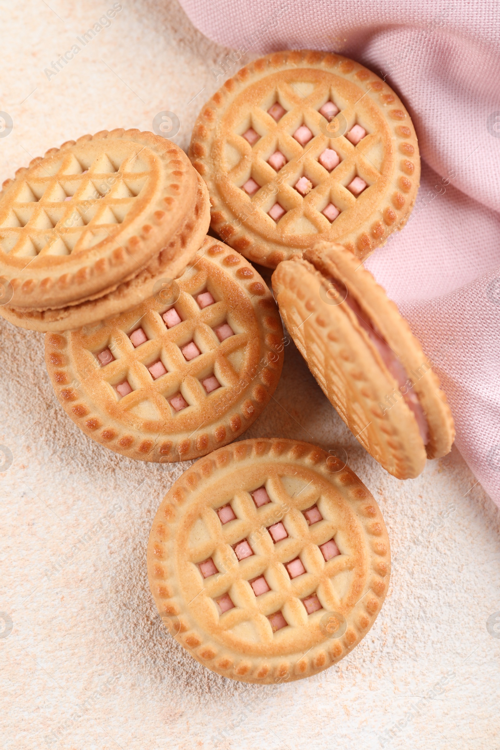 Photo of Tasty sandwich cookies with cream on beige background, flat lay