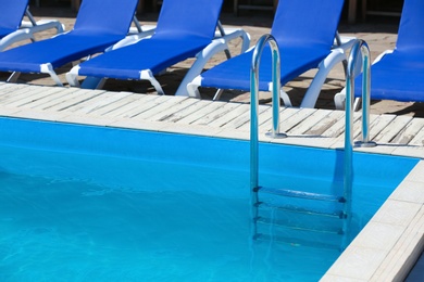 Photo of Modern swimming pool with step ladder outdoors