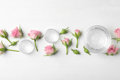Photo of Flat lay composition with cosmetic gel and beautiful flowers on white wooden table