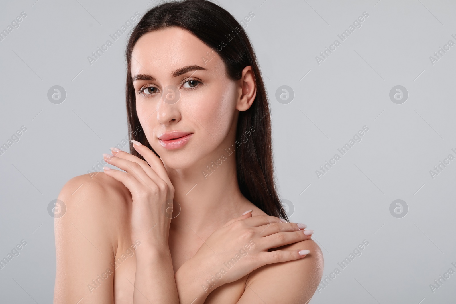 Photo of Portrait of beautiful young woman on light grey background. Space for text