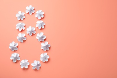 Number 8 made with white paper flowers and space for text on coral background, flat lay. International Women's day