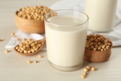 Fresh soy milk and beans on wooden table, closeup