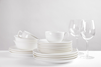 Photo of Set of clean dishes on white table