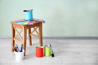 Paint and decorator's tools near light wall