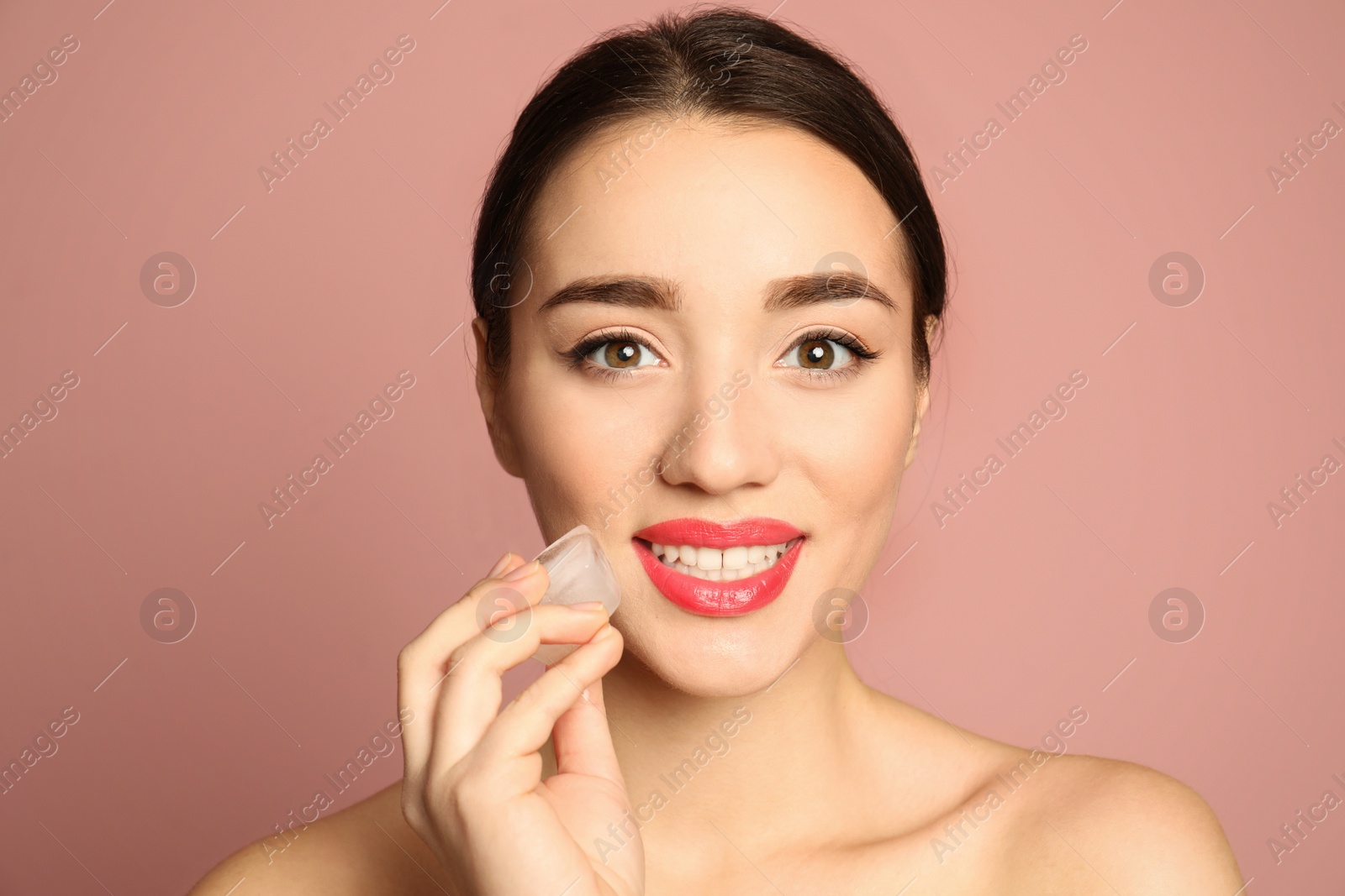 Photo of Young woman with ice cube on color background. Skin care
