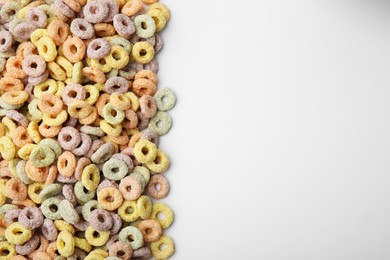 Photo of Tasty cereal rings on white background, flat lay. Space for text