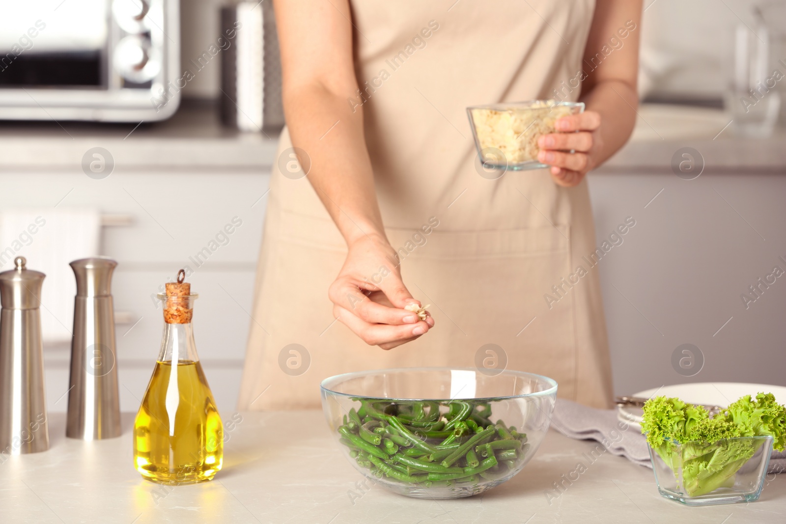 Photo of Woman preparing healthy salad with green beans at table