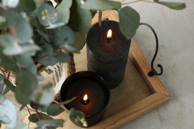 Photo of Tray with burning candles and green branches on table, above view