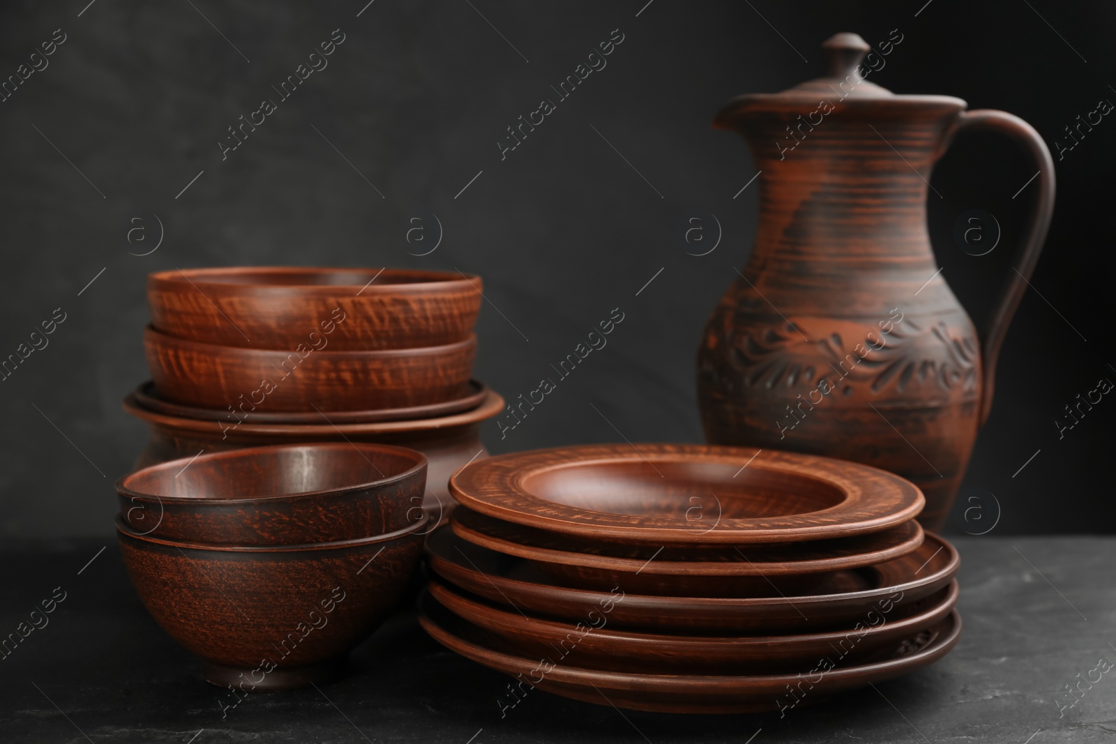 Photo of Set of clay utensils on black table