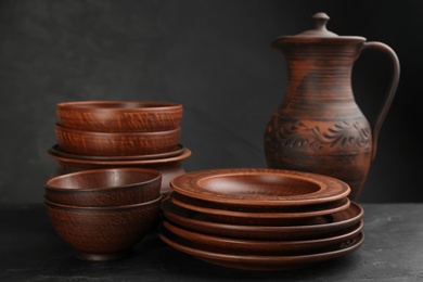 Photo of Set of clay utensils on black table