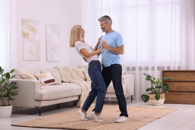 Happy affectionate couple dancing at home, space for text. Romantic date
