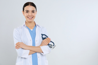 Portrait of young doctor with stethoscope on white background