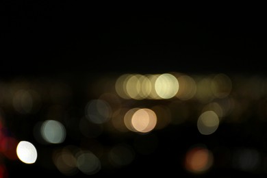 Blurred view of glowing lights outdoors, bokeh effect