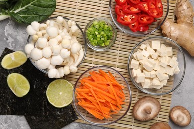 Cooking delicious ramen soup. Different ingredients on table, flat lay