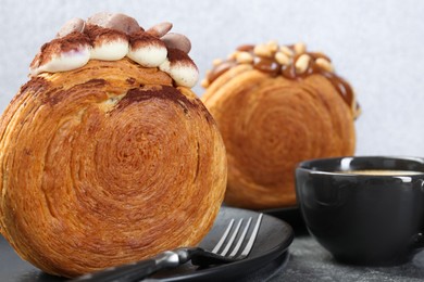 Photo of Tasty puff pastry. Round croissants served with coffee on grey table, closeup