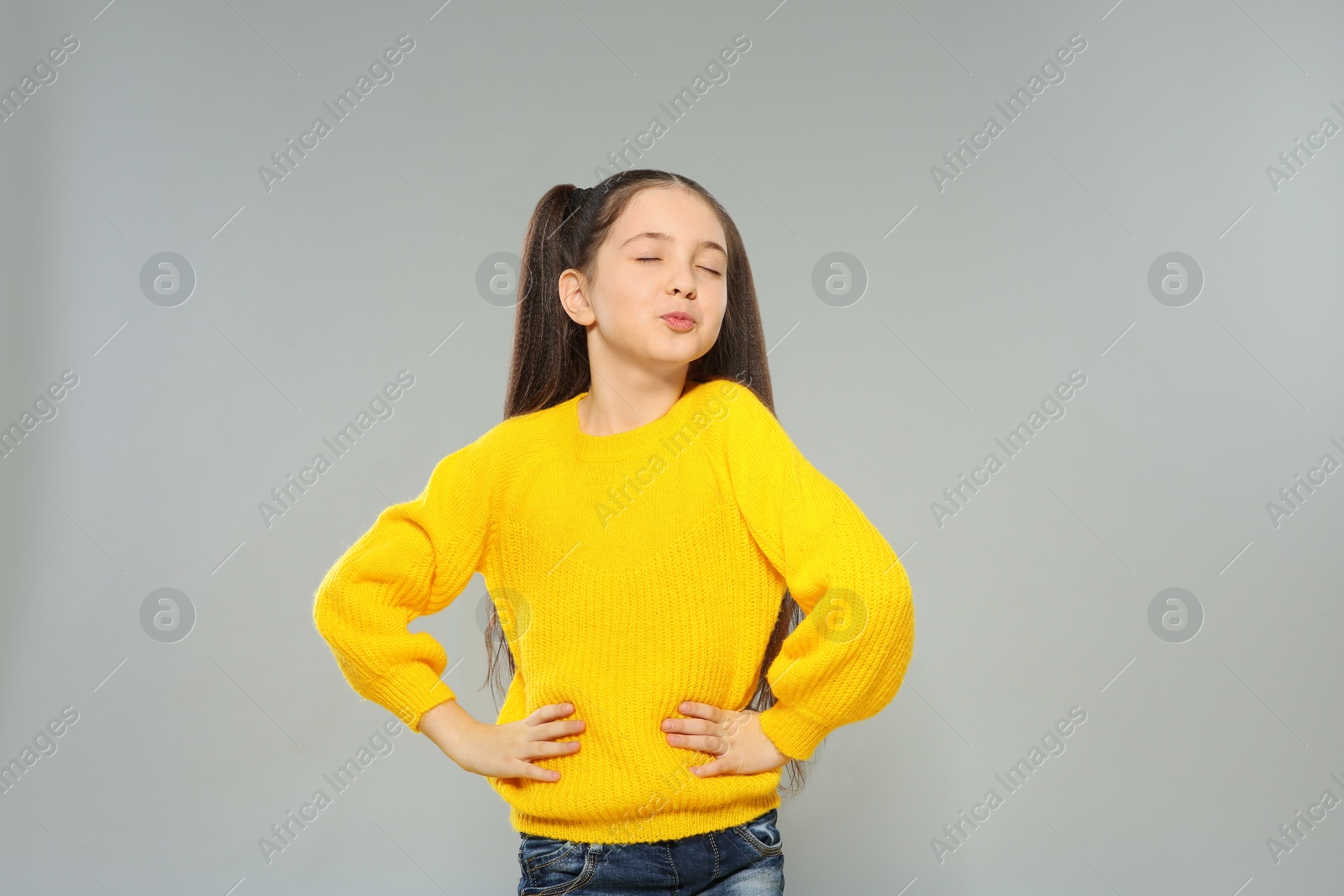Photo of Portrait of little girl posing on grey background