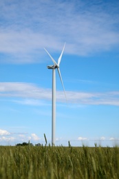 Photo of Beautiful view of field with wind turbine. Alternative energy source