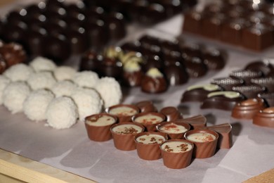 Many delicious chocolate candies on table, closeup. Production line