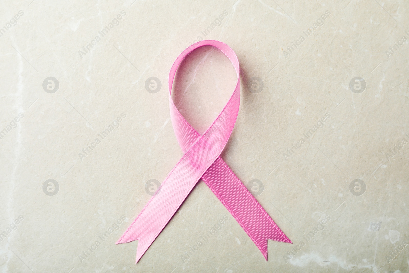 Photo of Pink ribbon on grey background, top view. Breast cancer awareness concept