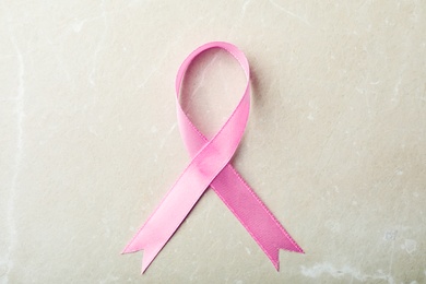 Pink ribbon on grey background, top view. Breast cancer awareness concept
