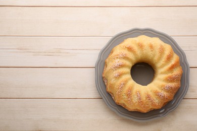 Photo of Delicious freshly baked sponge cake on wooden table, top view. Space for text