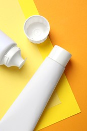 Photo of Blank tubes of toothpaste on color background, flat lay