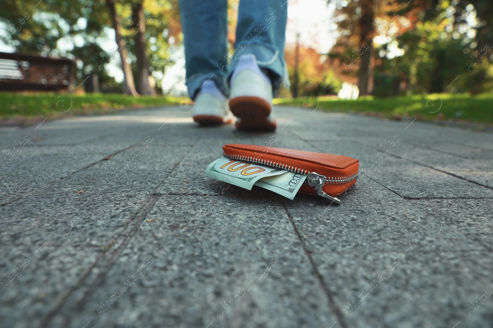 Photo of Woman lost her purse on pavement outdoors, selective focus