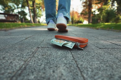 Photo of Woman lost her purse on pavement outdoors, selective focus