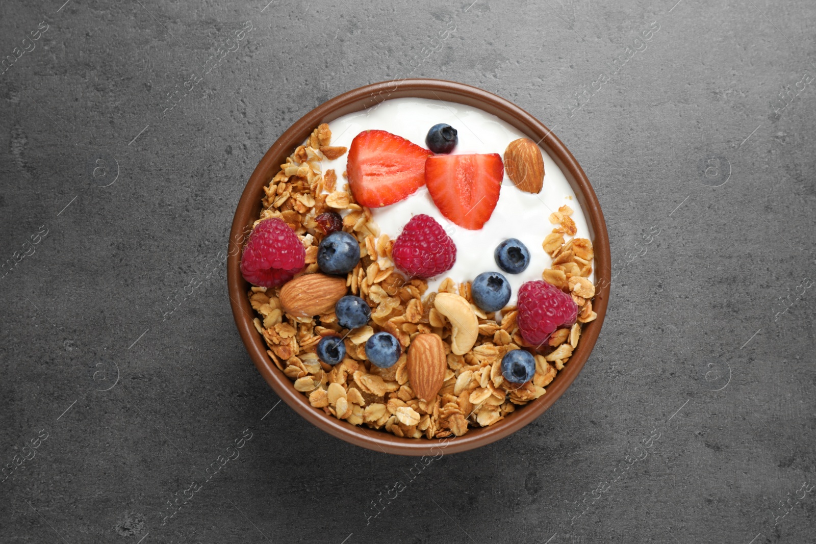 Photo of Tasty homemade granola served  on grey table, top view. Healthy breakfast