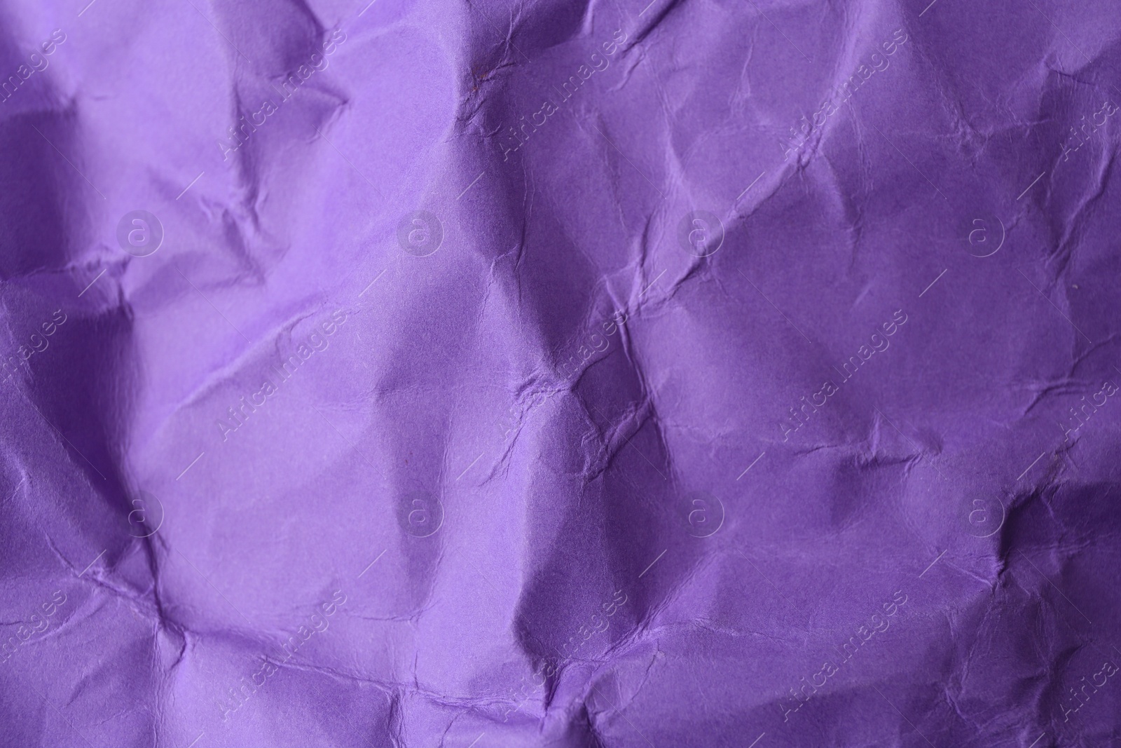 Photo of Sheet of crumpled violet paper as background, top view