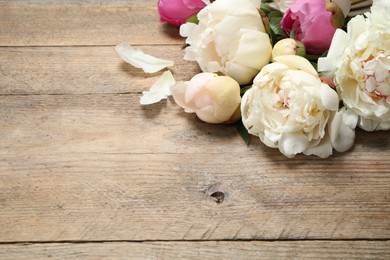 Photo of Beautiful peonies on wooden background. Space for text