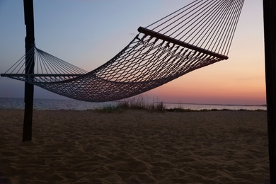 Photo of Empty hammock on beach at sunset. Time to relax