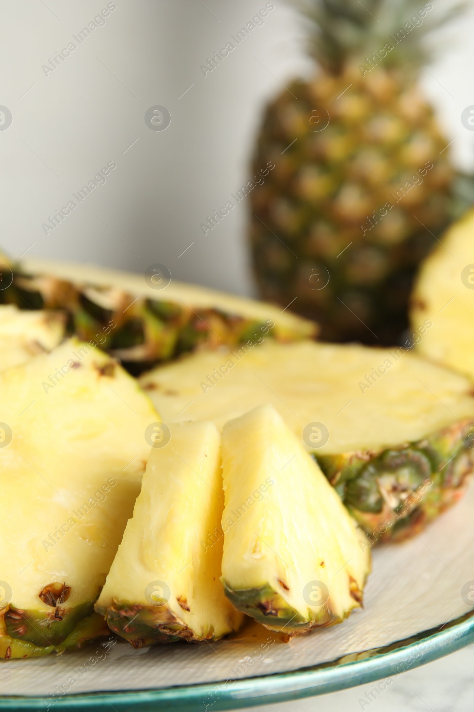 Photo of Plate with tasty cut pineapple on table, closeup