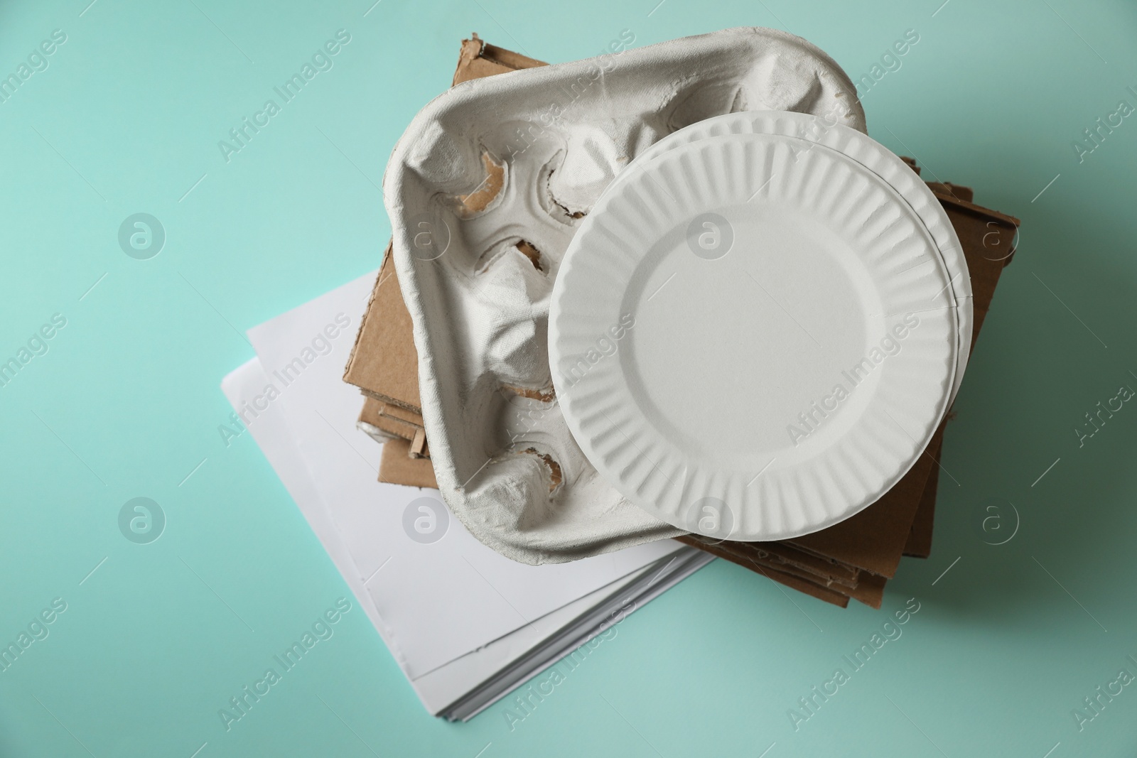 Photo of Heap of waste paper on turquoise background, top view
