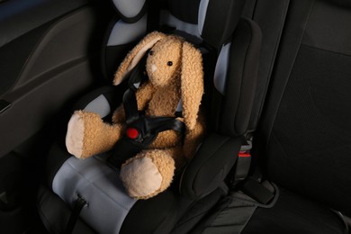 Photo of Toy bunny in child safety seat inside car