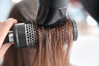 Photo of Professional hairdresser working with client in salon