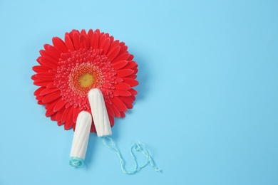 Photo of Flat lay composition with flower and tampons on color background. Gynecological checkup