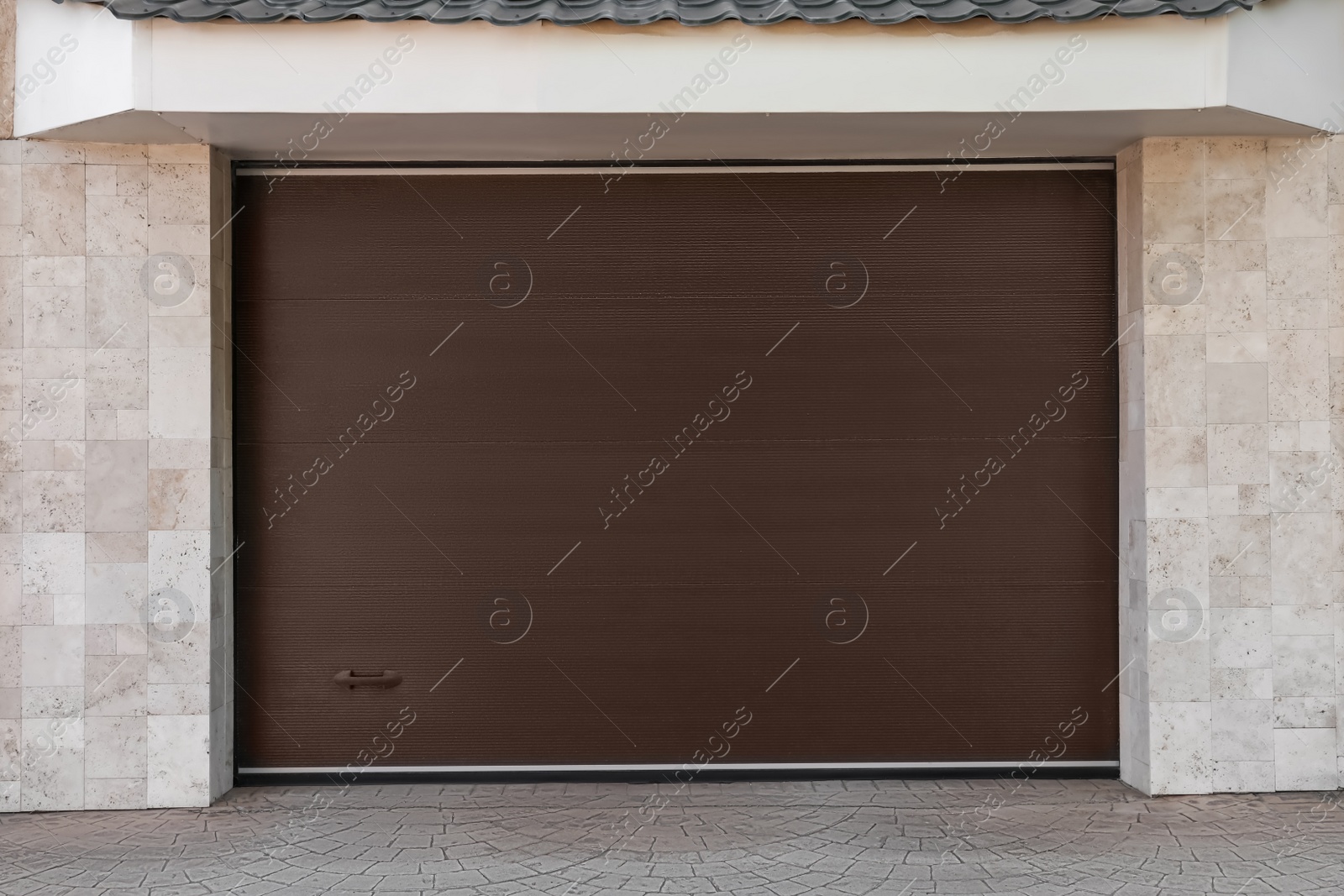 Photo of Brown modern counterweight garage doors on building