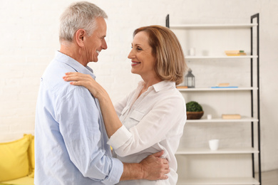 Happy senior couple dancing together at home