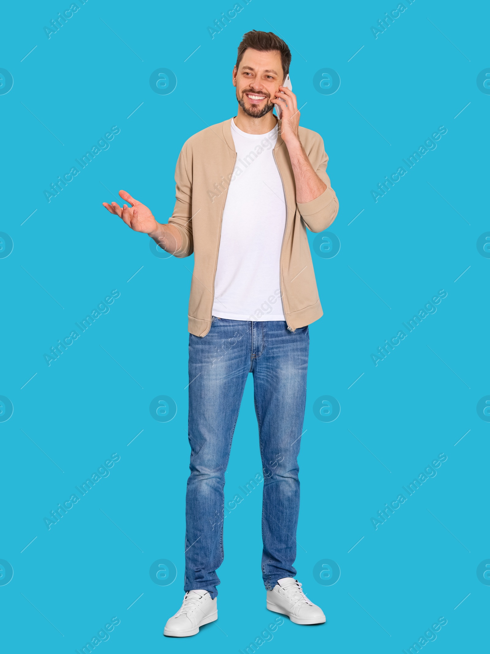 Photo of Man talking on phone against light blue background