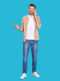 Photo of Man talking on phone against light blue background