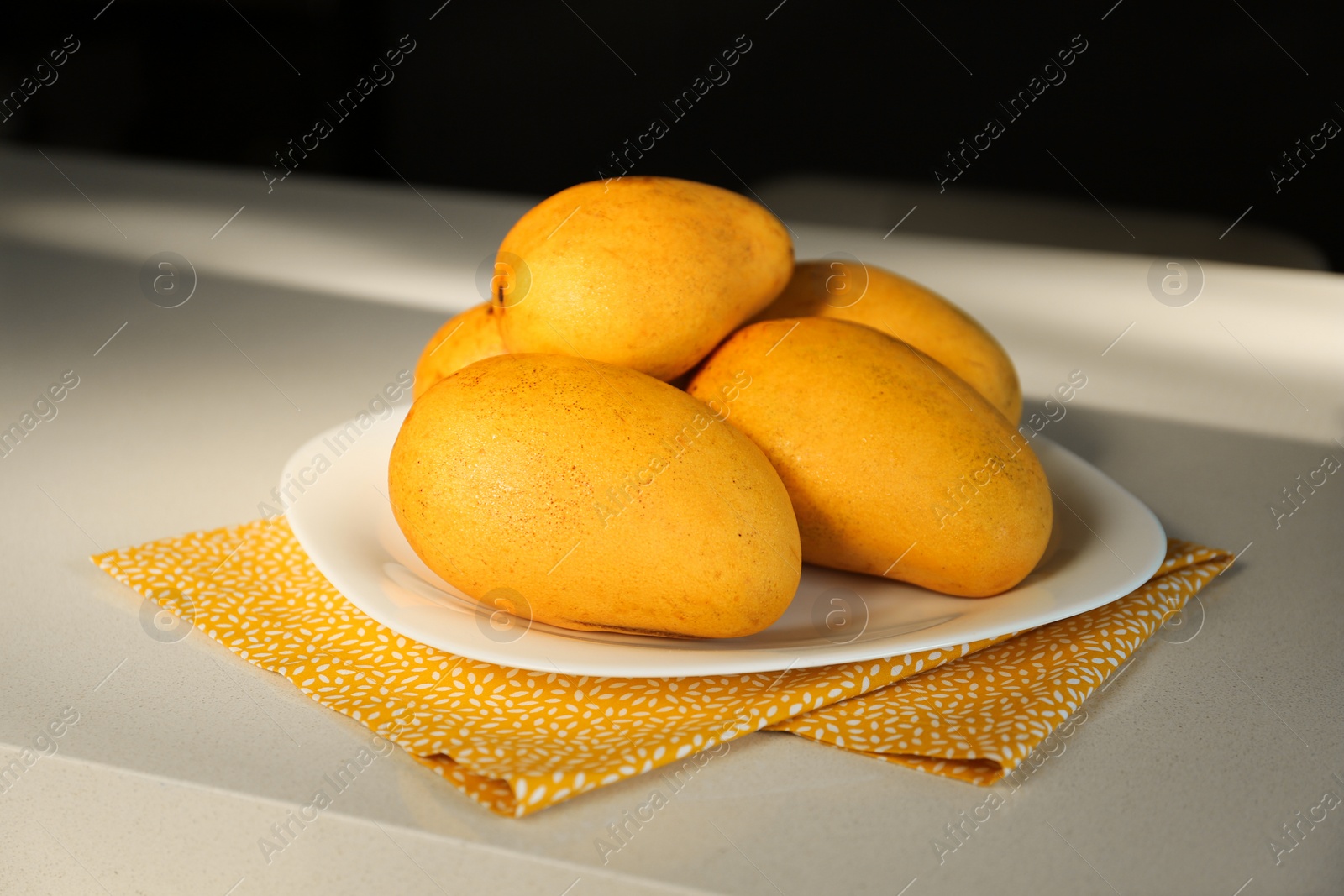 Photo of Delicious ripe fresh mangos on white table