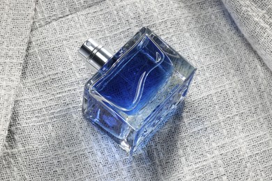 Luxury men's perfume in bottle on grey jacket