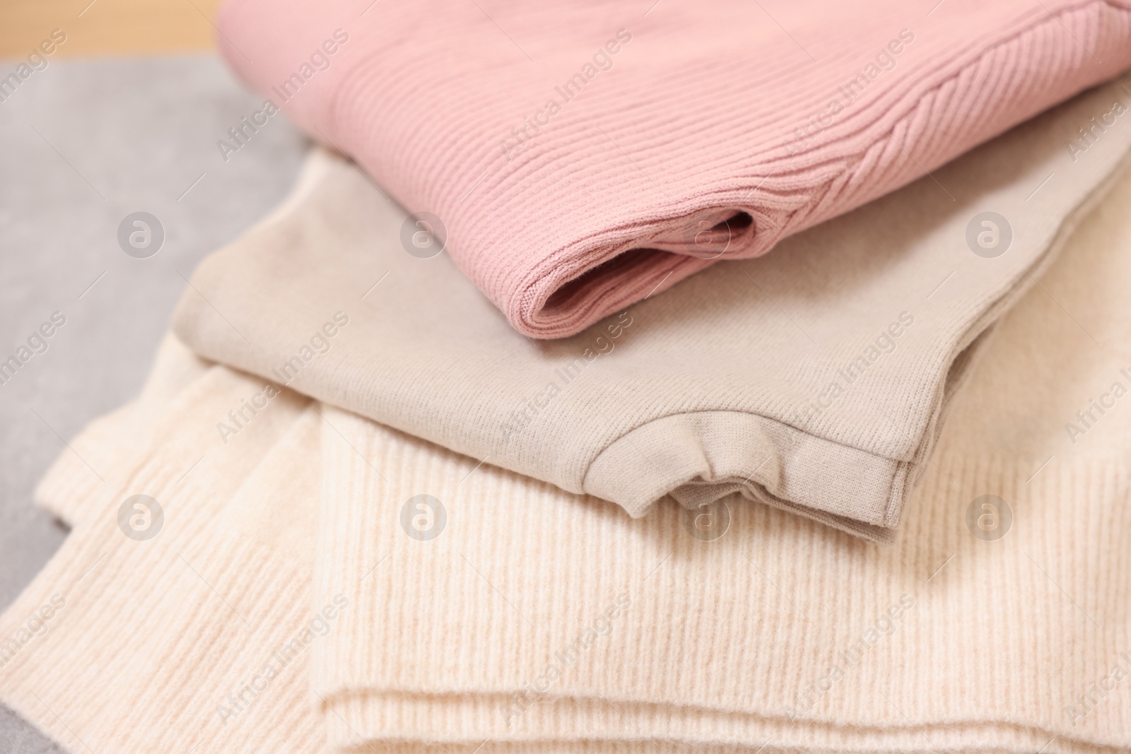 Photo of Stack of folded clothes on grey table, closeup