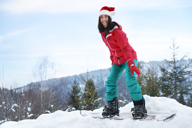 Photo of Young snowboarder wearing winter sport clothes on hill