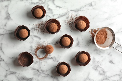 Flat lay composition with tasty raw chocolate truffles on marble background
